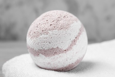 Photo of Bath bomb and towel on table, closeup
