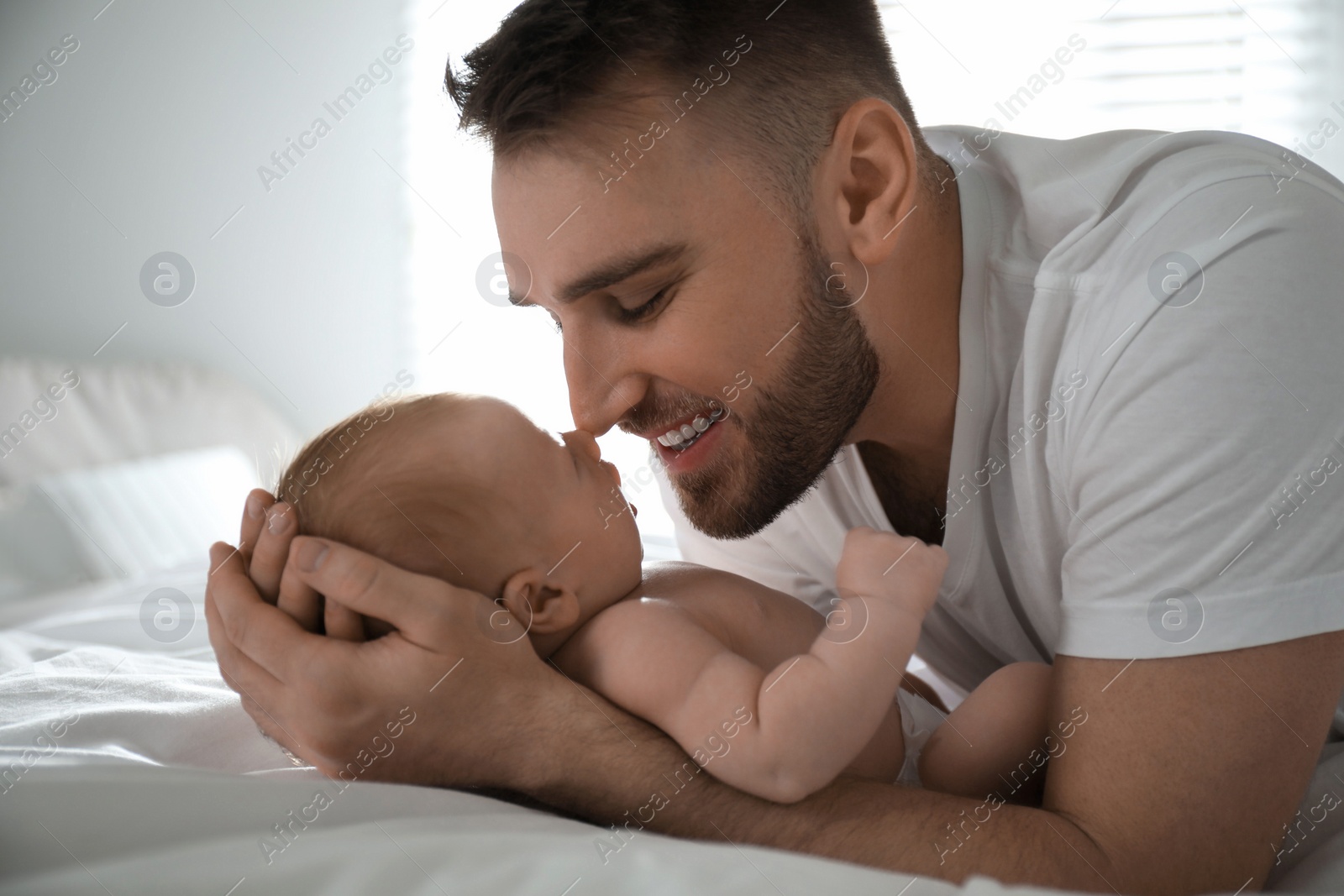 Photo of Father with his newborn son at home