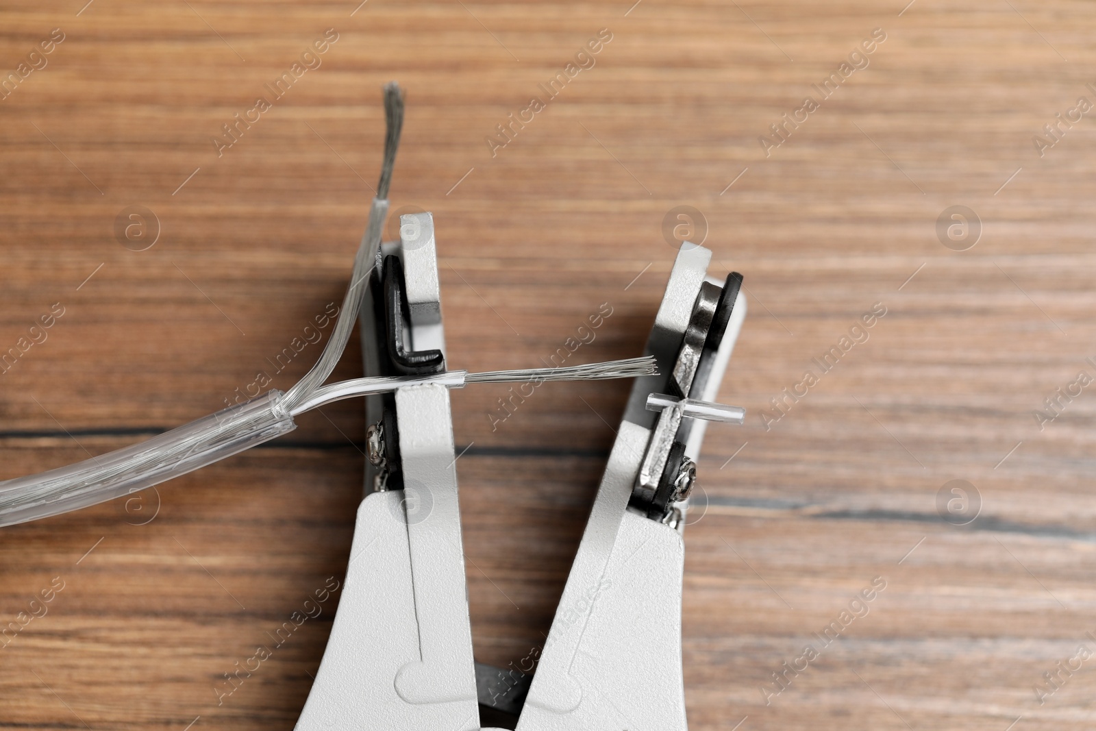 Photo of Cutters and stripped wire on wooden table, closeup