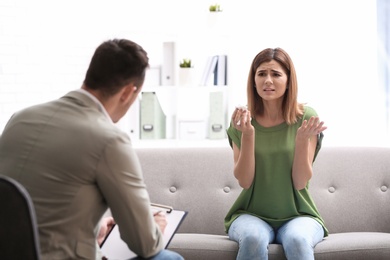 Psychotherapist working with woman in light office