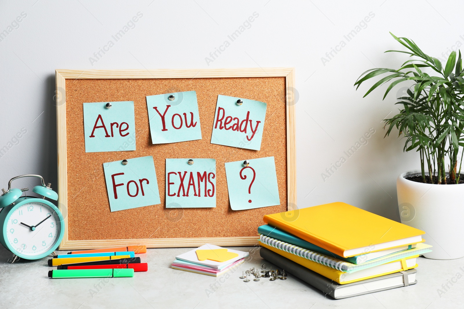 Photo of Cork board with question Are You Ready For Exams made of sticky notes on table