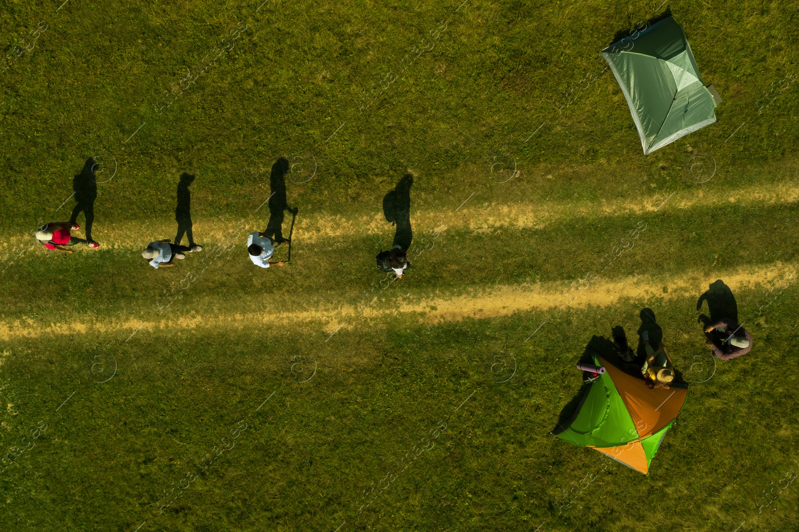 Image of Group of tourists near tents in campsite, top aerial view. Drone photography