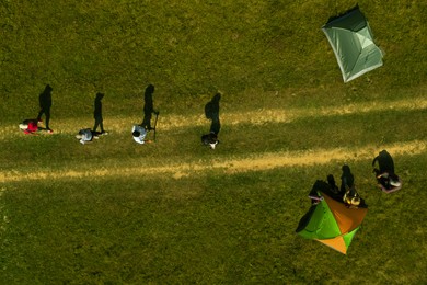 Group of tourists near tents in campsite, top aerial view. Drone photography