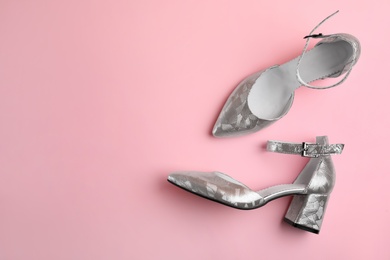 Photo of Stylish silver female shoes on pink background, flat lay. Space for text