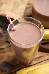 Photo of Fresh yummy chocolate milk on wooden table, closeup