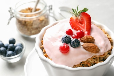 Bowl with yogurt, berries and granola on table, closeup