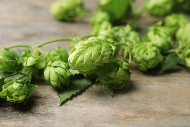 Photo of Fresh green hops on wooden table. Beer production