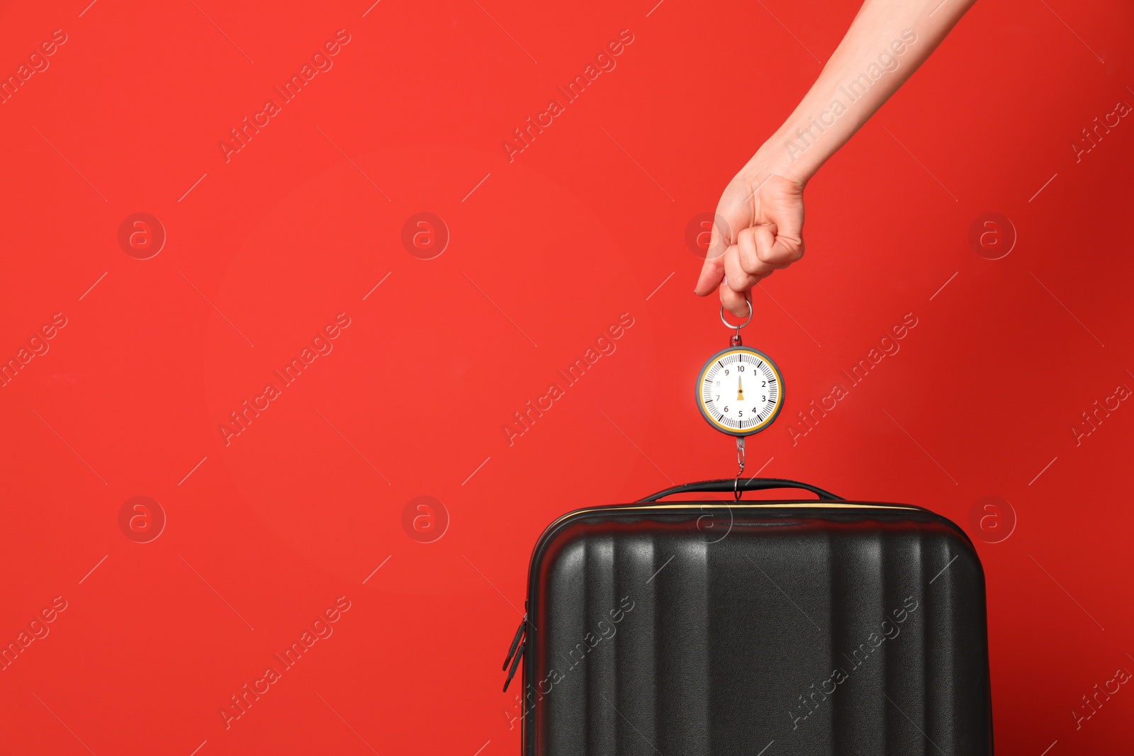 Photo of Woman weighing suitcase against color background, closeup. Space for text