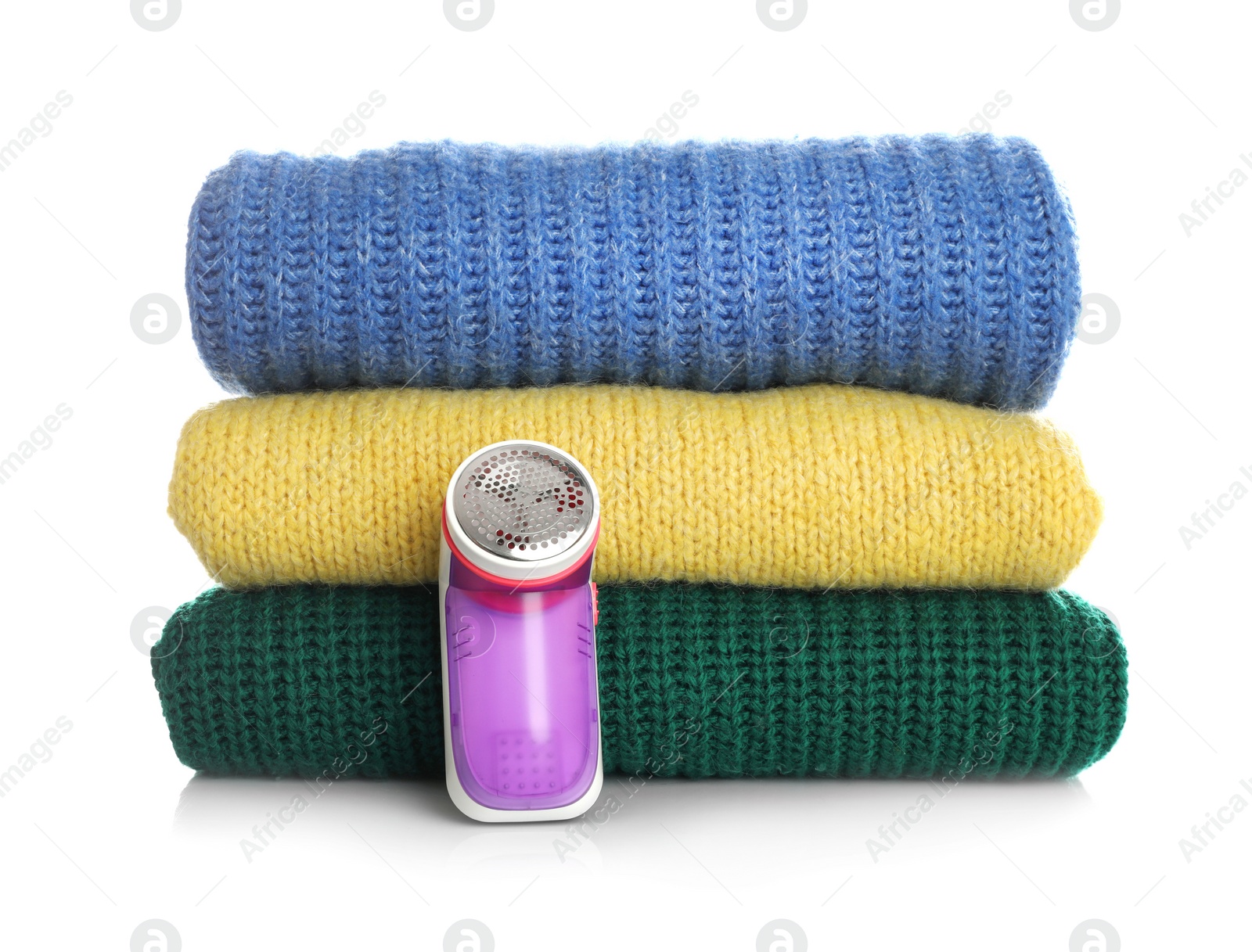 Photo of Modern fabric shaver and woolen clothes on white background