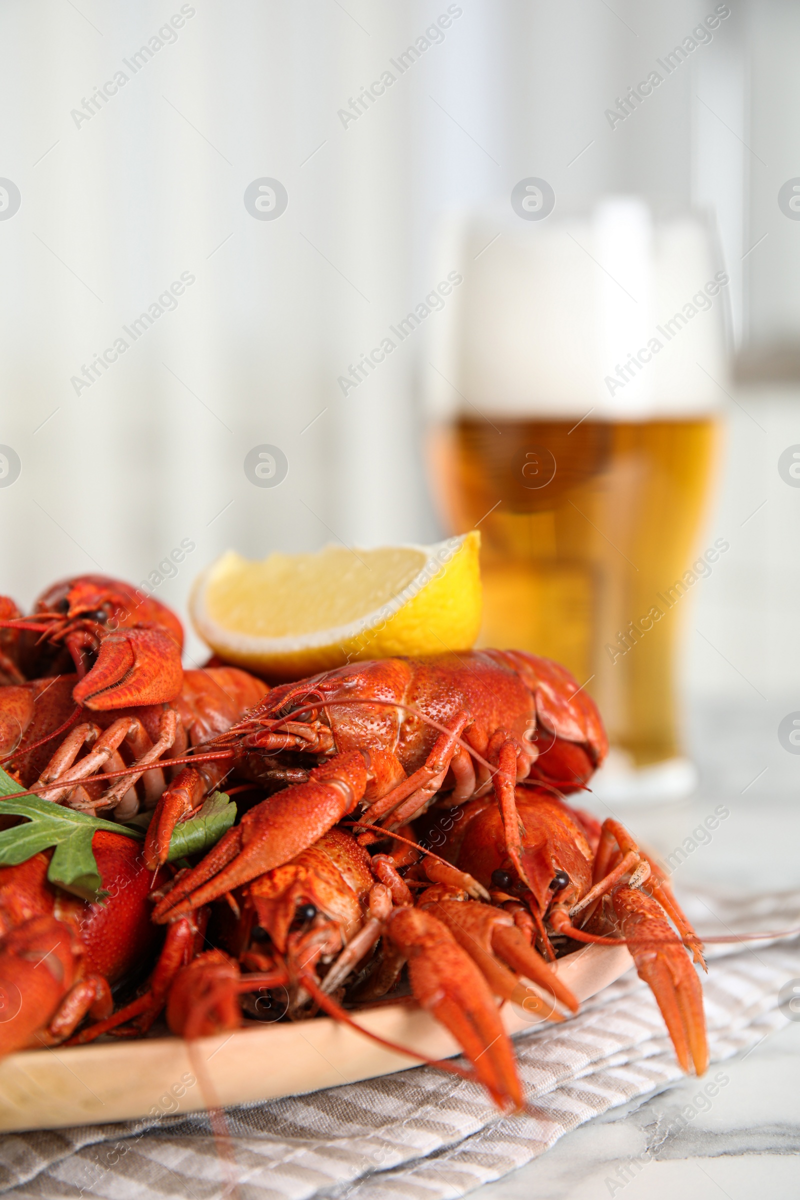 Photo of Delicious boiled crayfishes on white table, closeup