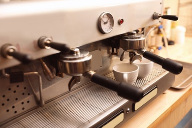 Preparing fresh aromatic coffee using modern machine, closeup