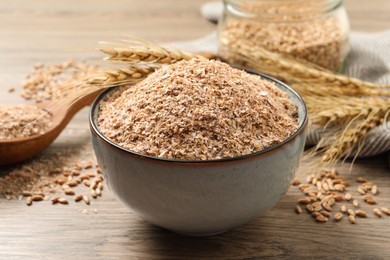 Photo of Wheat bran and kernels on wooden table