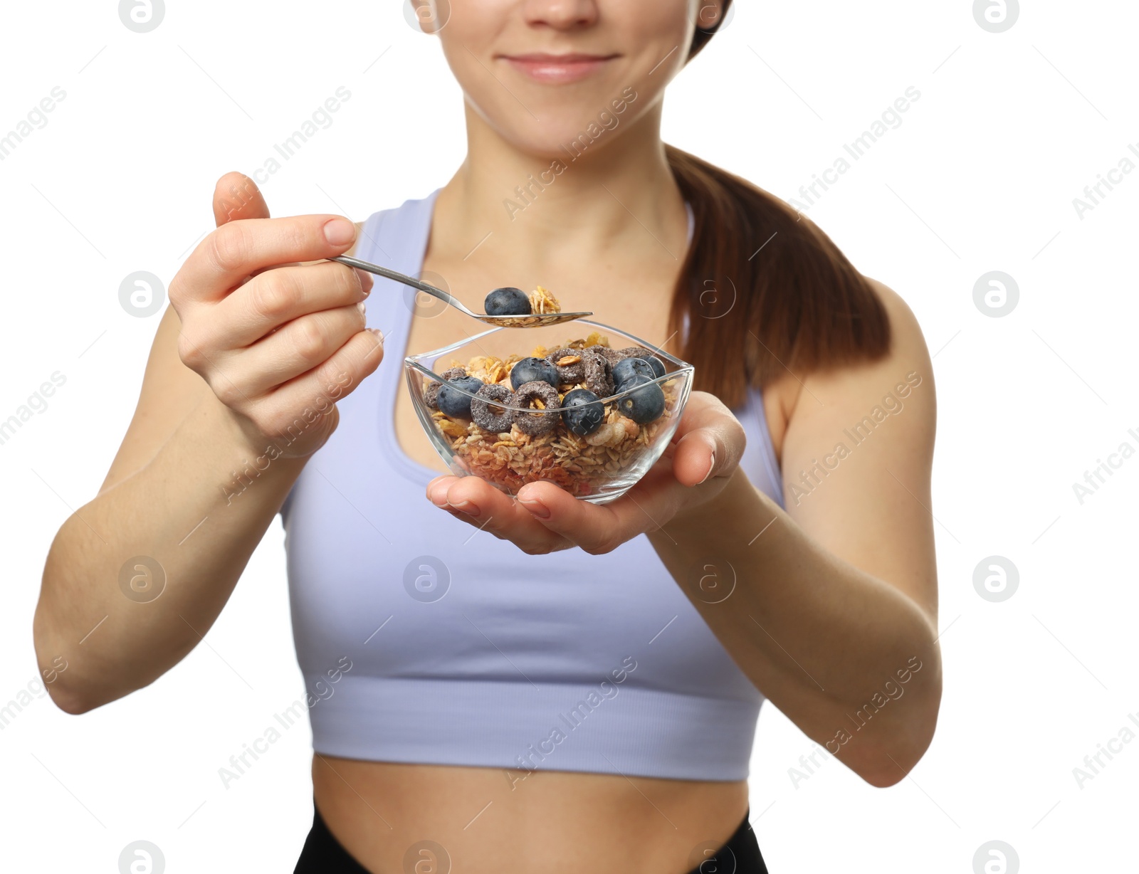 Photo of Woman eating tasty granola with fresh berries on white background, closeup