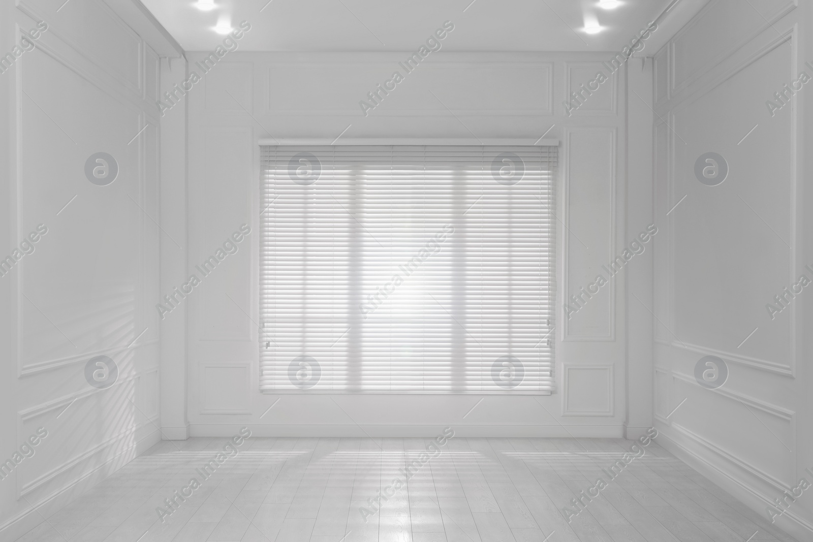 Photo of Empty room with white walls, large window and wooden floor