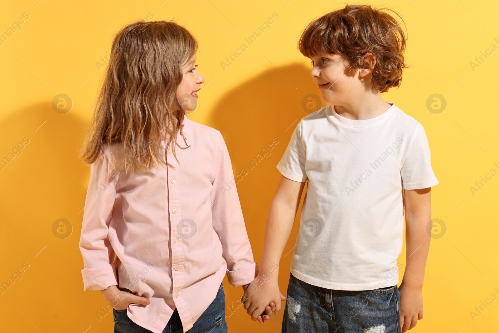 Photo of Fashion concept. Stylish children posing on yellow background