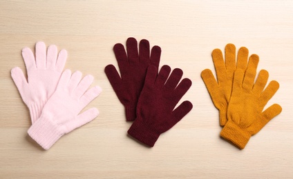 Set of stylish gloves on white wooden background, flat lay