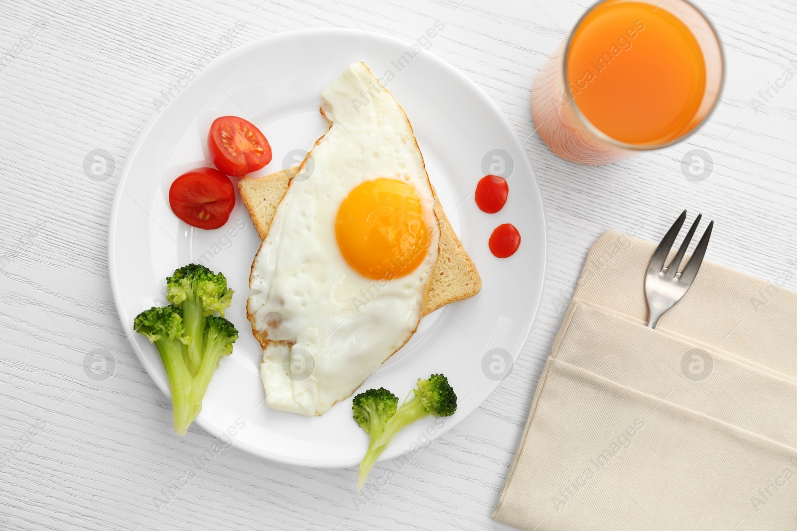 Photo of Tasty fried eggs with vegetables and juice on white wooden table, flat lay. Delicious morning meal