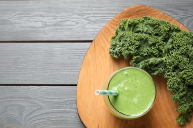 Tasty kale smoothie on light grey wooden table, flat lay. Space for text