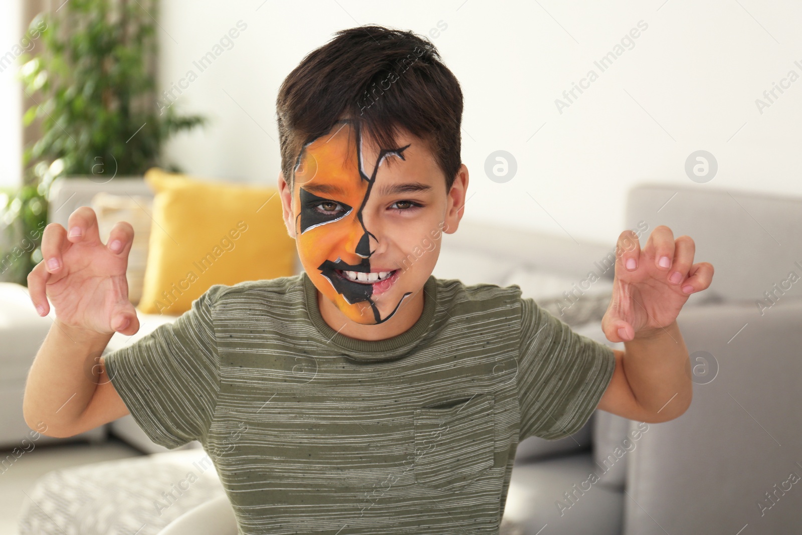 Photo of Cute little boy with face painting indoors