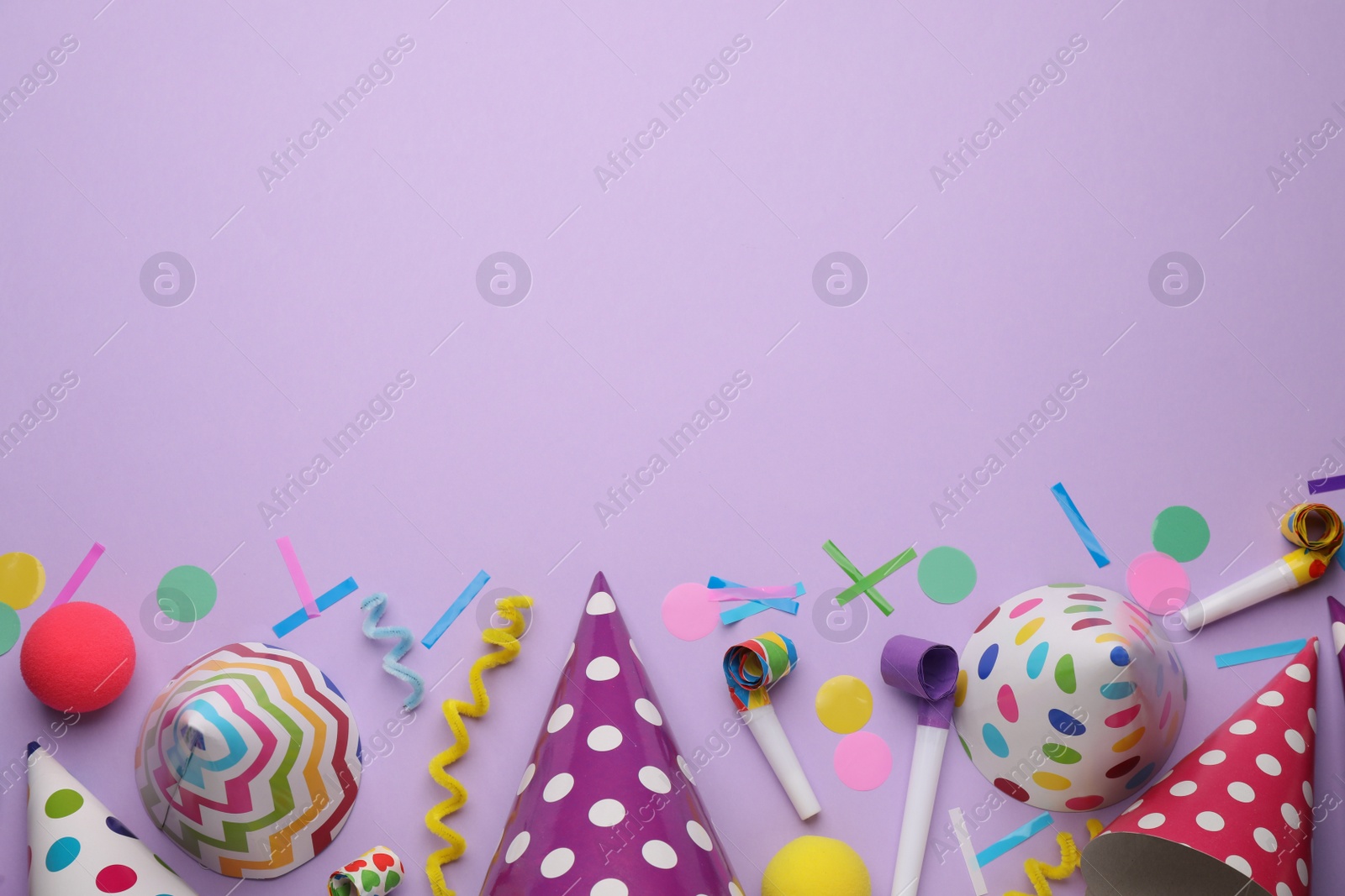 Photo of Flat lay composition with party hats and other festive items on violet background. Space for text