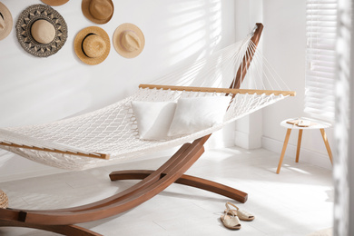 Comfortable hammock with pillows in stylish room. Interior design