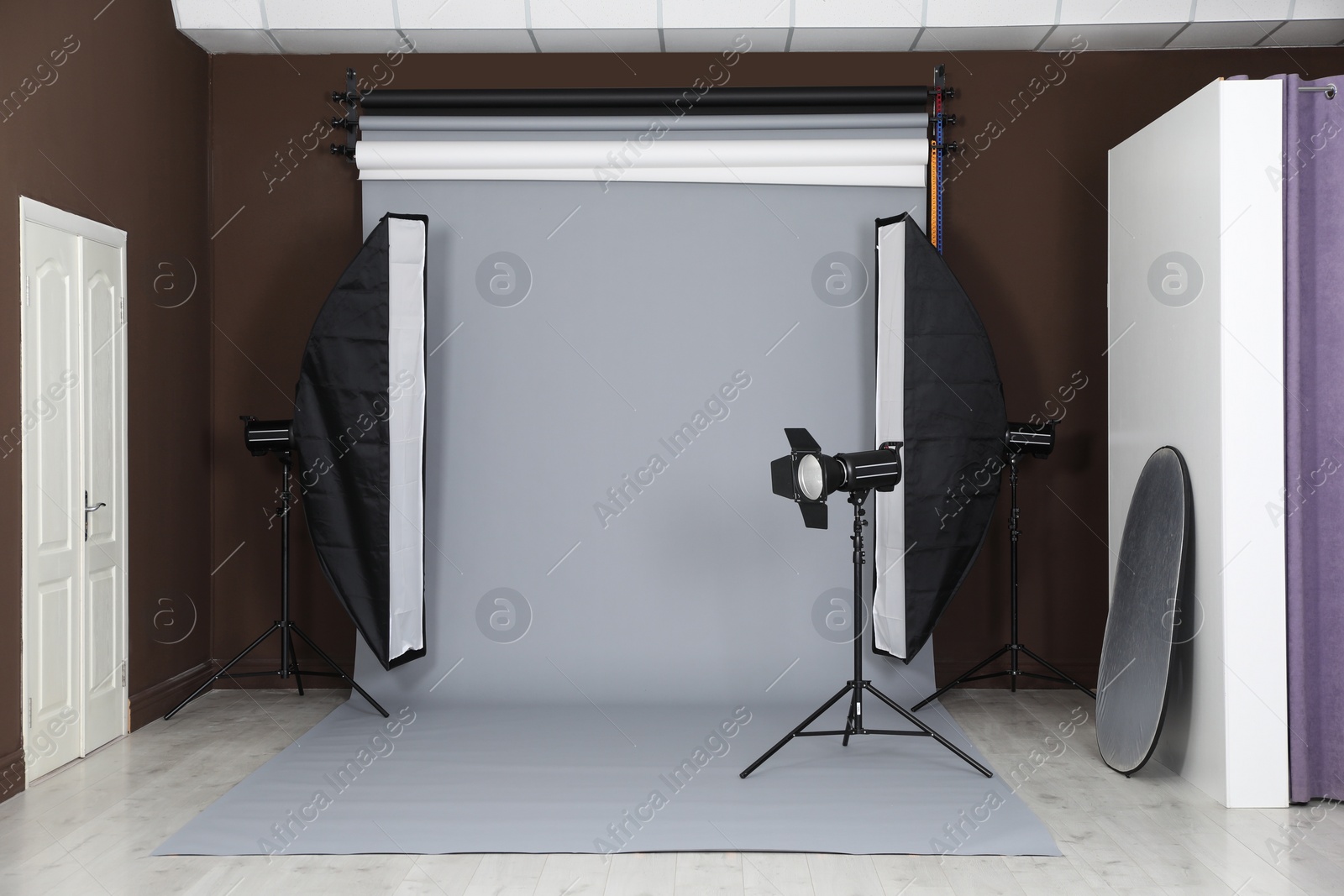 Photo of Grey photo background and professional lighting equipment in studio