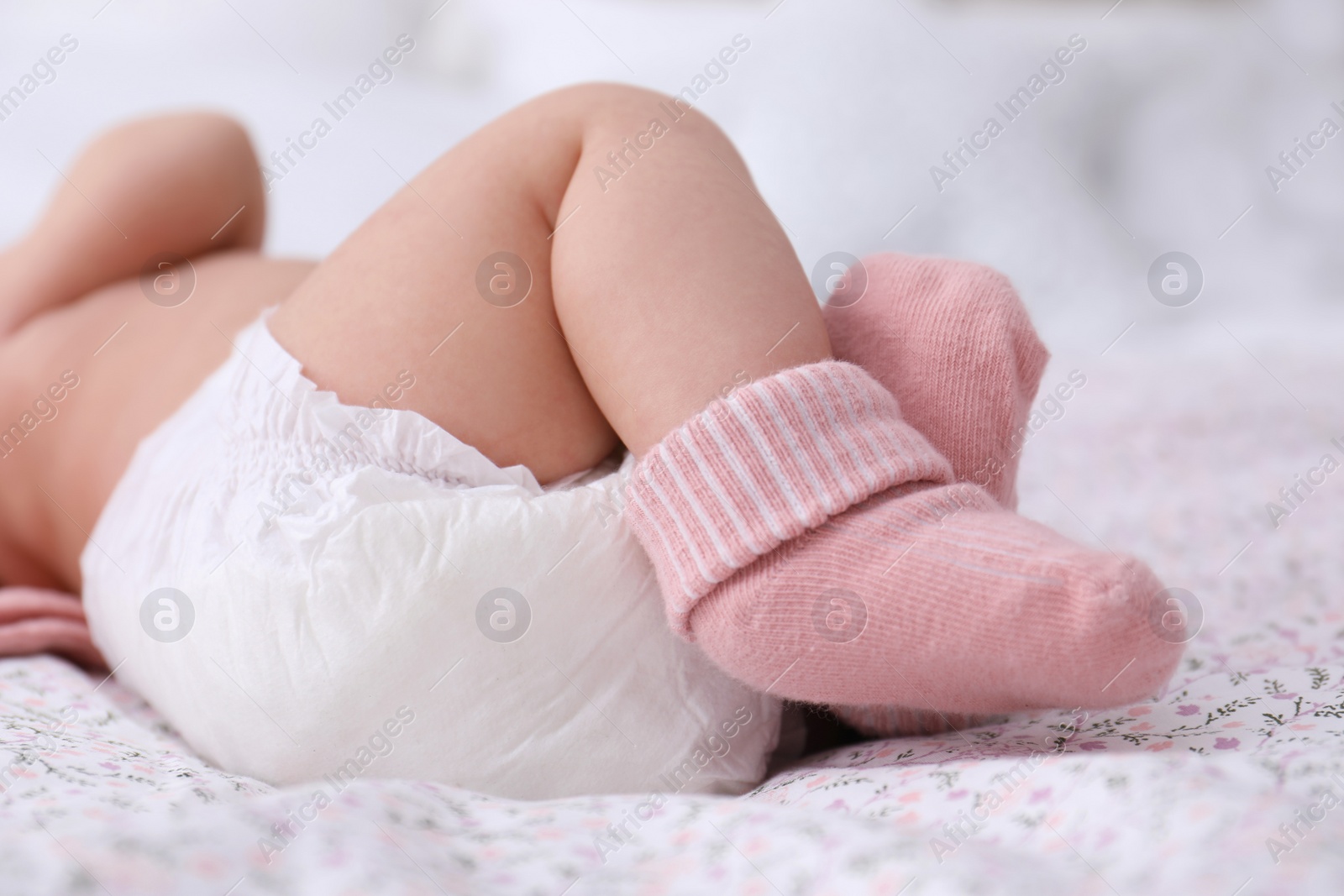 Photo of Little baby in diaper on bed, closeup