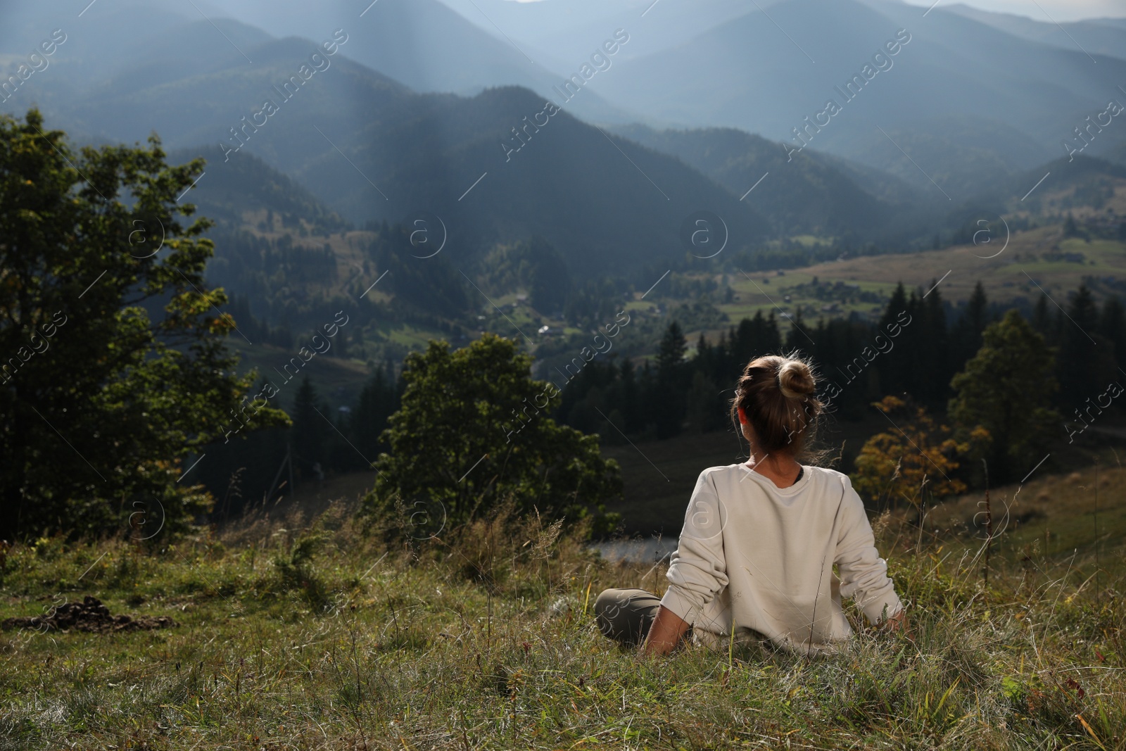 Photo of Woman enjoying beautiful mountain landscape, back view. Space for text