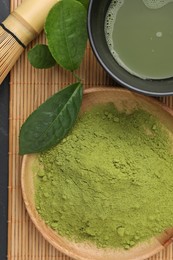 Green matcha powder, fresh beverage and leaves on table, flat lay