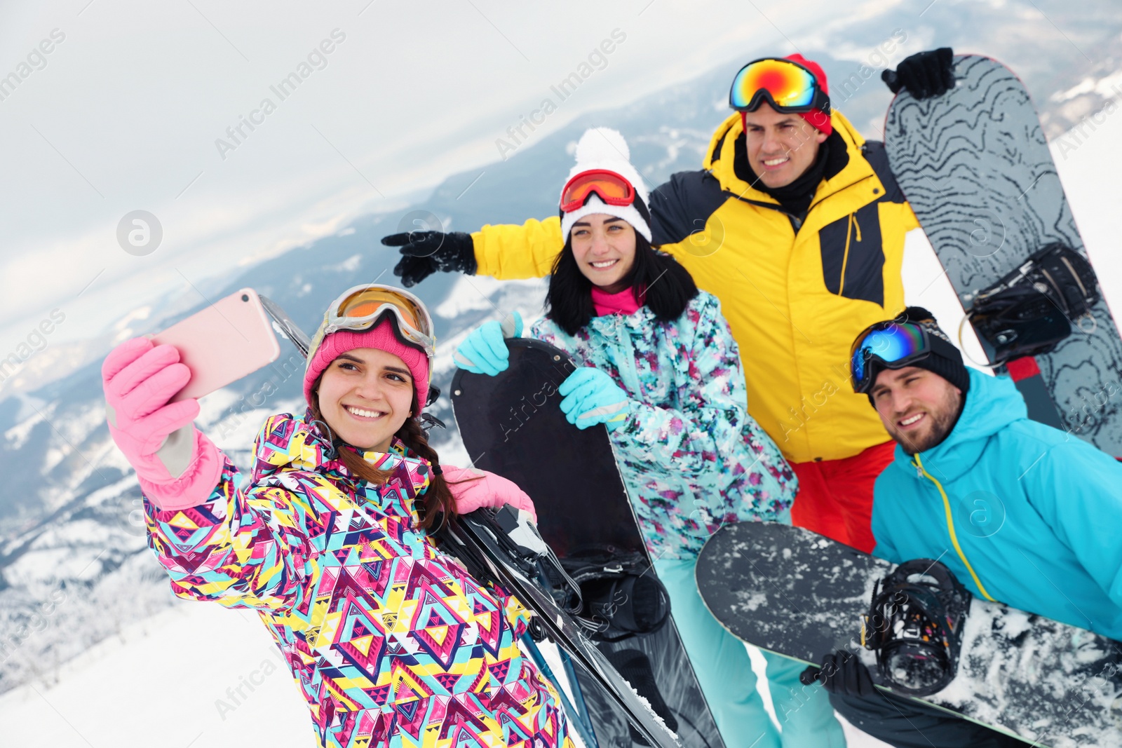 Photo of Group of friends taking selfie in mountains. Winter vacation