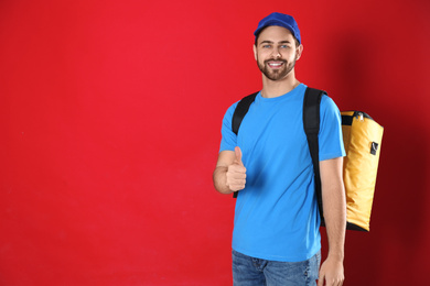 Photo of Courier with thermo bag on red background, space for text. Food delivery service