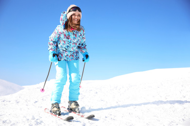 Photo of Young woman skiing on hill, space for text. Winter vacation