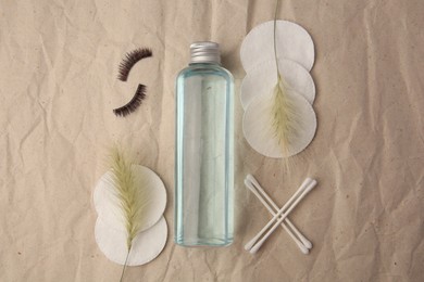 Photo of Flat lay composition with makeup remover and false eyelashes on crumpled paper