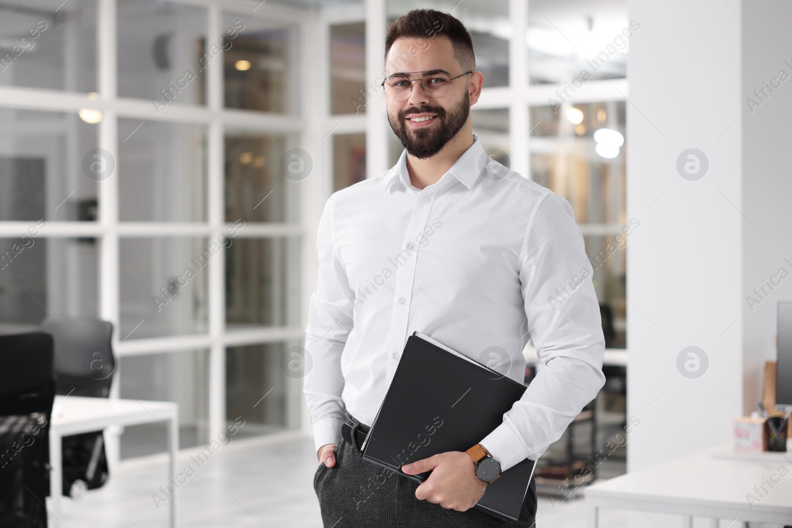 Photo of Portrait of smiling man with folder in office. Lawyer, businessman, accountant or manager