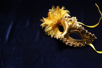 Photo of Theater arts. Golden venetian carnival mask on blue fabric, space for text