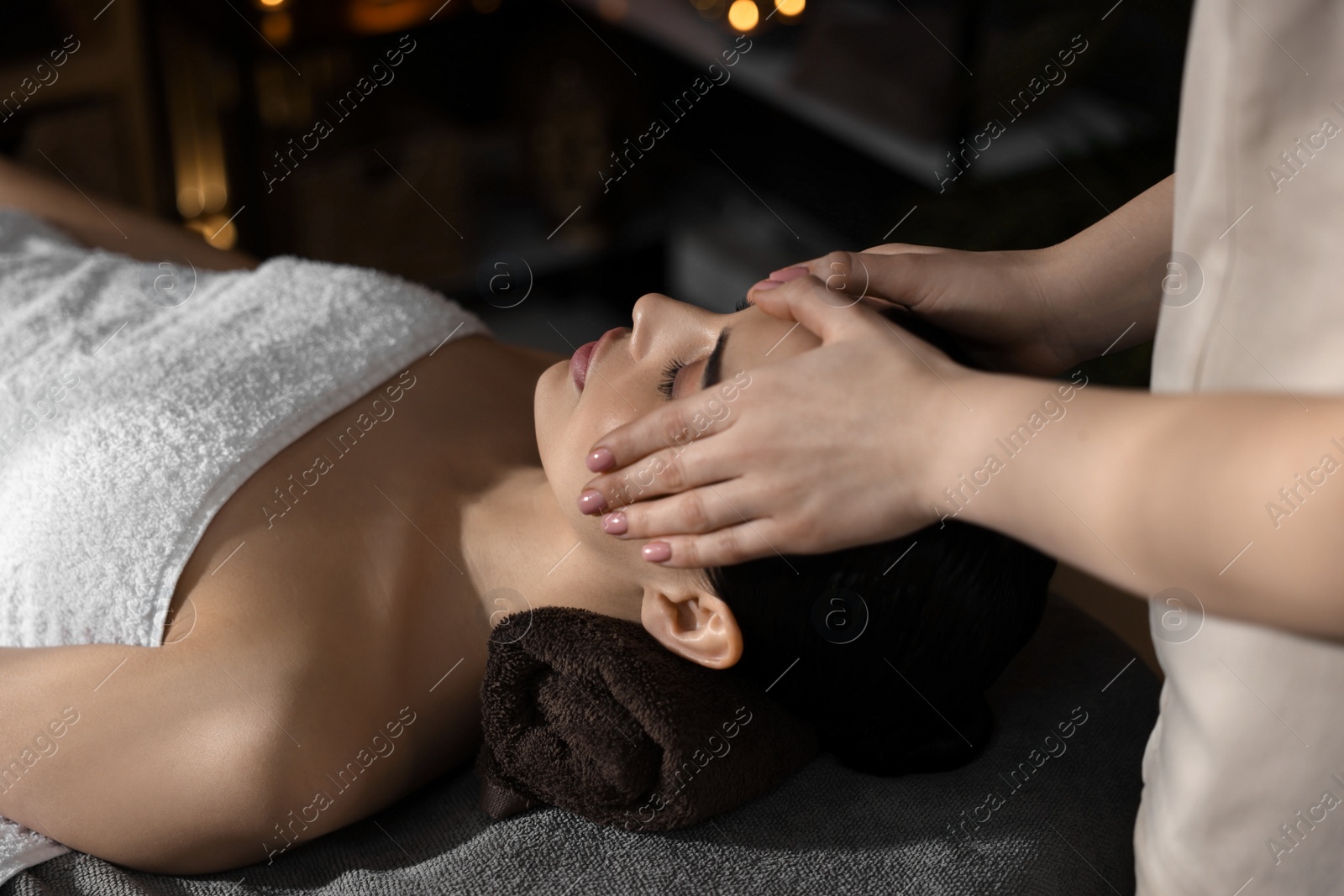 Photo of Spa therapy. Beautiful young woman lying on table during massage in salon