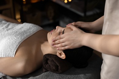 Spa therapy. Beautiful young woman lying on table during massage in salon