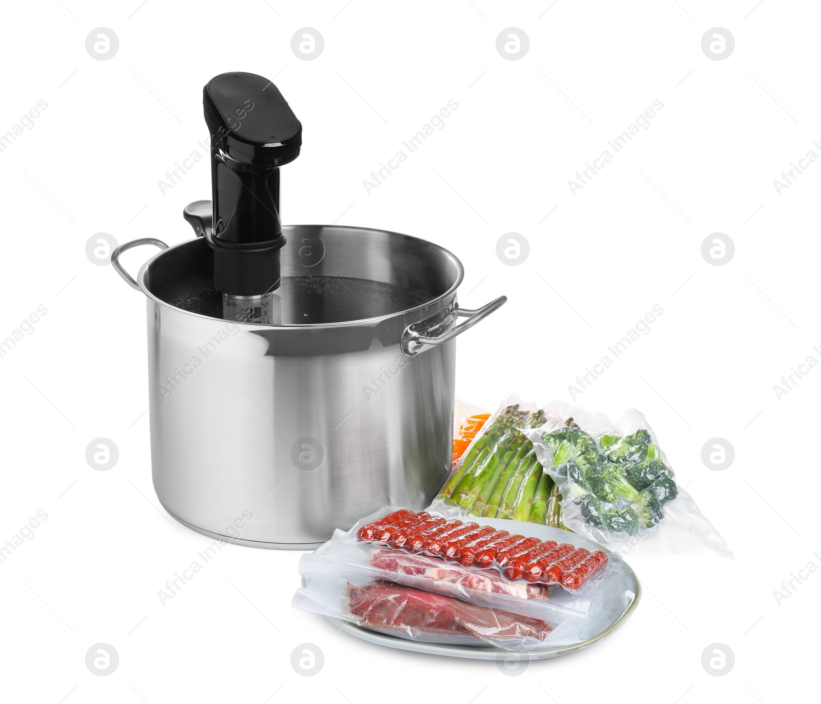 Photo of Thermal immersion circulator in pot and vacuum packs with different food products on white background. Sous vide cooking