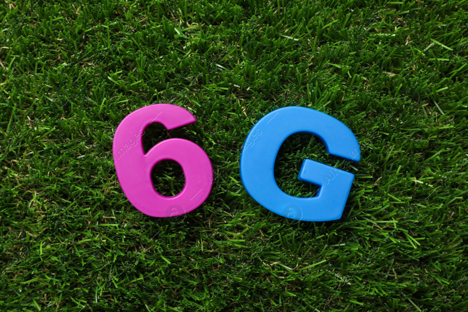 Photo of 6G technology, Internet concept. Number and letter on green grass, flat lay