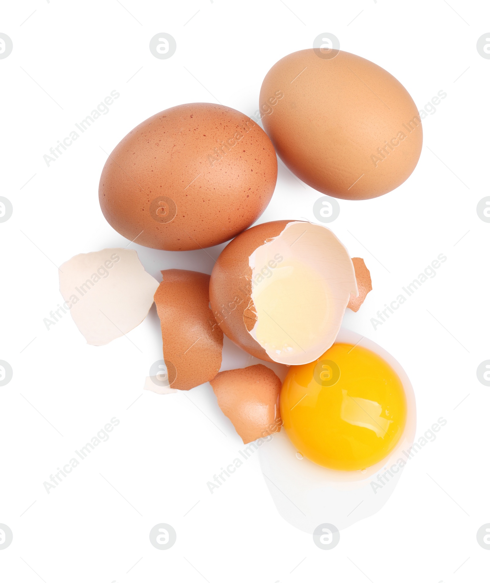 Photo of Chicken eggs, pieces of shell and yolk isolated on white, top view