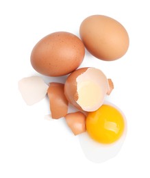 Photo of Chicken eggs, pieces of shell and yolk isolated on white, top view