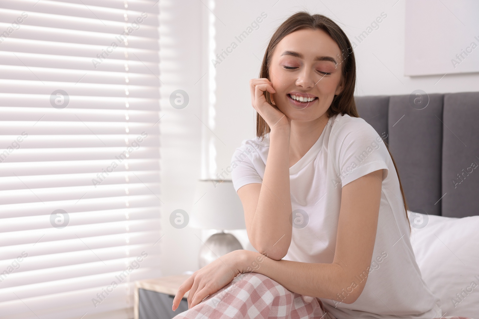 Photo of Portrait of beautiful woman laughing in bedroom. Space for text