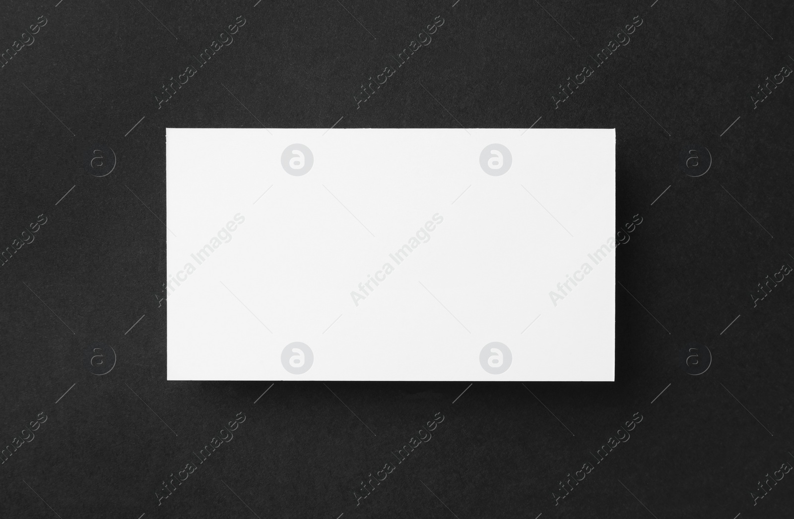 Photo of One blank business card on black background, top view. Mockup for design