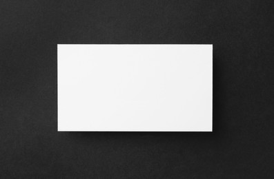 One blank business card on black background, top view. Mockup for design