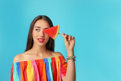 Beautiful young woman posing with watermelon on color background