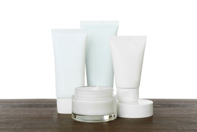 Photo of Set of cosmetic products in jar and tubes on wooden table against white background
