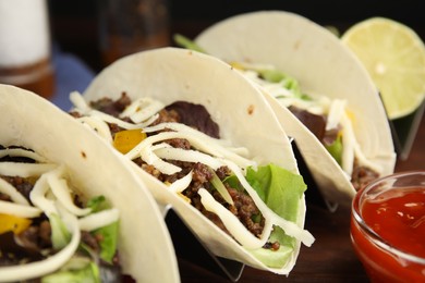 Delicious tacos with fried meat and cheese on table, closeup