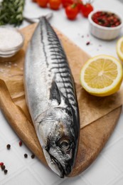 Photo of Raw mackerel, lemon and peppercorns on white table
