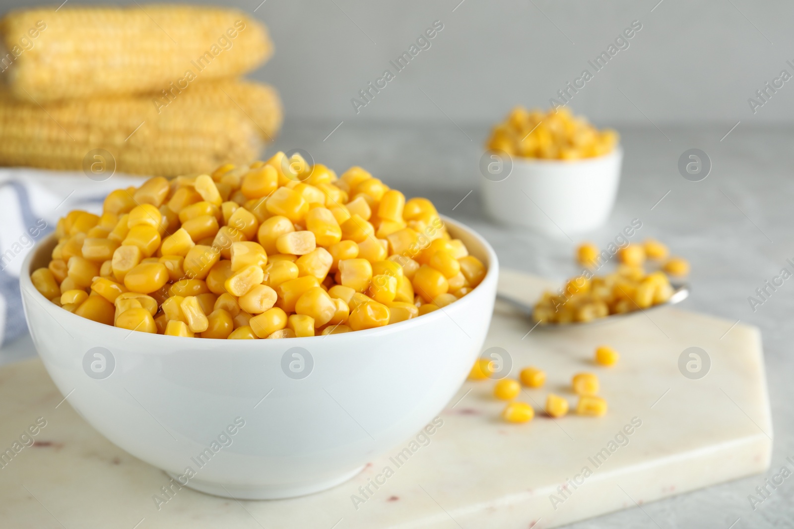 Photo of Delicious canned corn in bowl on light table, closeup