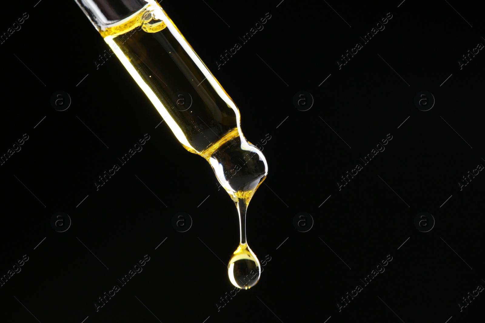 Photo of Dripping tincture from pipette on black background, closeup. Space for text